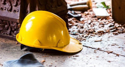accident at construction site and hard hat on floor